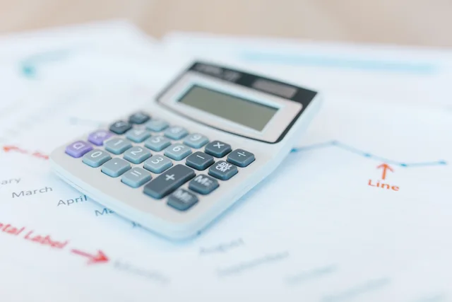 Close-up of a calculator on financial documents with graphs and analysis papers. Reporting errors that quietly undermine corporate communications measurement